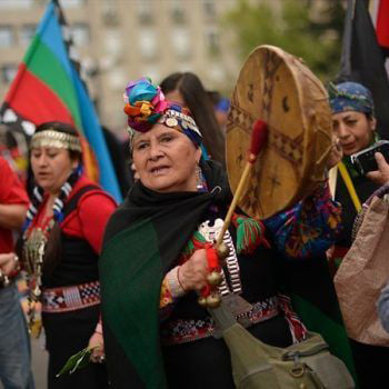 Mapuche woman playing drum.